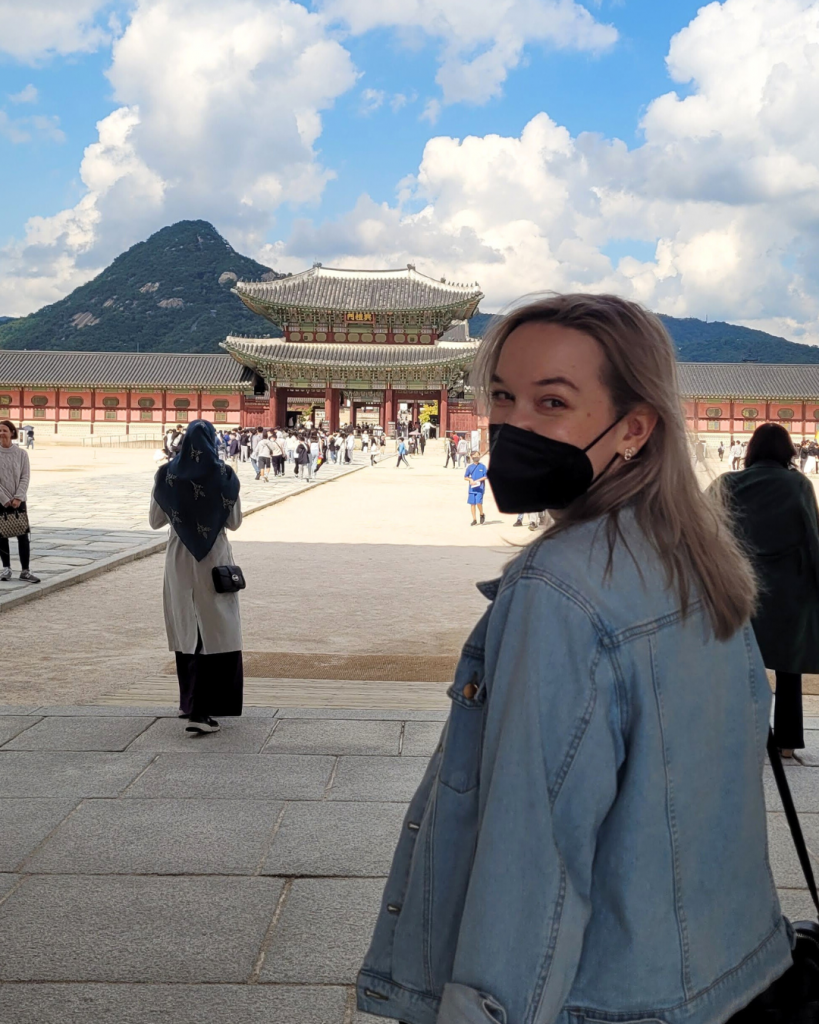 pleaselie standing in front of gyeongbokgung, a palace in seoul