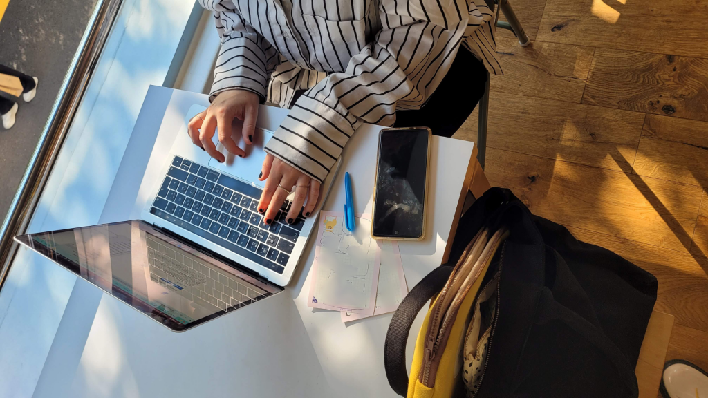 bird-eye view of hands typing on a laptop in a korean cafe